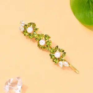 Elegante pinza para el cabello floral con brillantes estrases verdes, perlas y metal dorado.