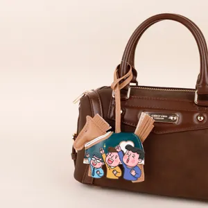 Detailed view of the stylish horse charm pendant with cartoon figures on brown PU leather handbag.