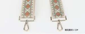 Close-up of the woven ethnic geometric diamond wide bag strap featuring durable gold metal clips.