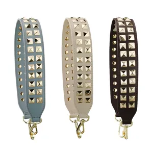 Brede vervangende tasband met gouden piramideklinknagels en metalen haken voor handtassen.