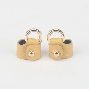 Gedetailleerd overzicht van de riemomvormingsgesp, geel leer met gouden metalen D-ring voor tas.