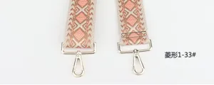 Detailed shot of ethnic geometric diamond pattern bag strap replacement with gold hardware hooks.