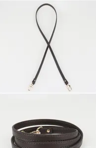 Détail de la bandoulière en cuir marron foncé, montrant la texture du cuir et les fermoirs robustes.
