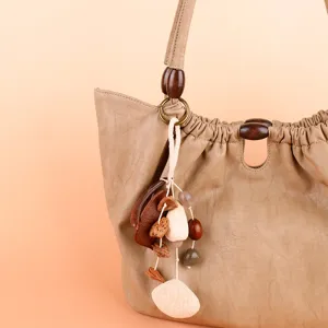 Close-up detail of natural plant pod bag charm with wooden beads and healing forest style.