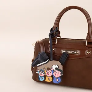 Brown PU leather handbag detail view featuring a cute cartoon character horse charm accessory.