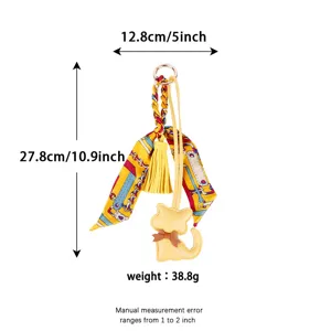 Chic yellow leather cat keychain with stylish silk scarf and tassel charm for bags.