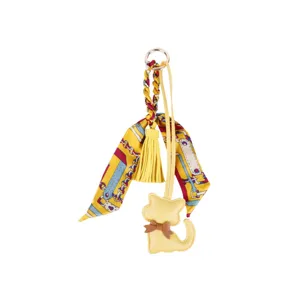 Cute yellow leather cat bag charm with braided silk twilly ribbon, tassel and keychain ring.