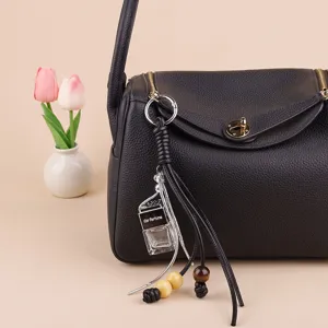 Car perfume pendant bag charm with glass bottle, leather tassels and wooden beads.