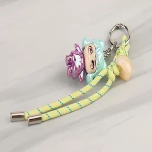 Colorful woven keychain with a cute designer doll figurine pendant, durable metal hardware for daily use.