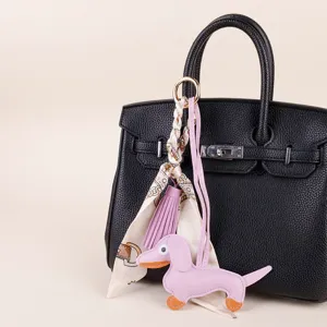 Cute dachshund dog bag charm with silk scarf and tassel pendant, stylish handbag accessory.