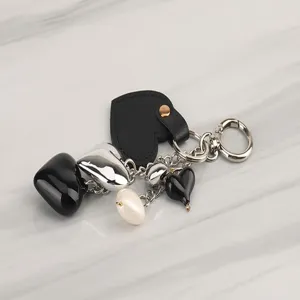 Chic heart keychain detail showcasing multiple metal and leather pendant charms for bags.