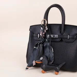 Black leather handbag with dachshund dog bag charm silk scarf tassel accessory elegant style