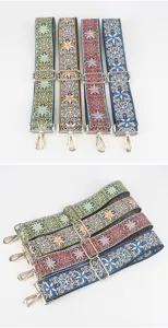 Close-up detail of colorful embroidered bag straps with adjustable metal buckles and hooks.