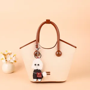 Beige PU tote bag with brown handle and cute fluffy puppy keychain for daily use.