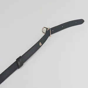 Detail view of black leather replacement bag strap with gold metal hardware and adjustable holes.