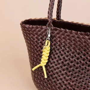 Minimalist leather braided rope bag charm and creative car keychain pendant detail shot.