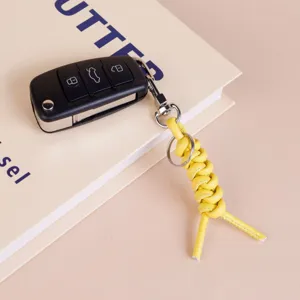 Yellow leather woven keychain minimalist bag pendant stylish car key ring holder for daily use.