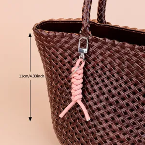 Minimalist leather woven keychain and bag charm for women, stylish wrist strap accessory.
