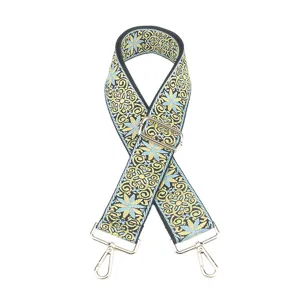 Wide replacement crossbody bag strap with ethnic floral jacquard pattern and metal hardware.