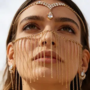 Close-up detail of a bohemian gold tassel face chain and headpiece with rhinestones.