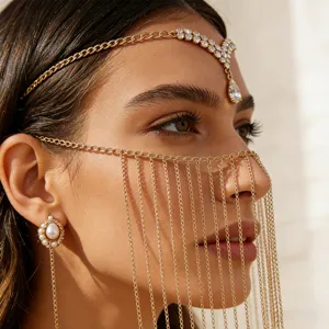 Close-up detail shot of bohemian gold tassel face chain and headpiece on model, stylish accessory.