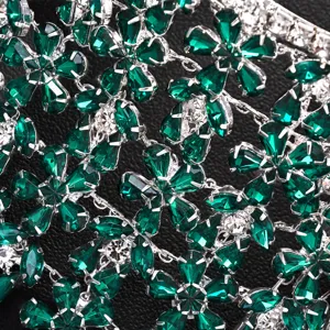 Nahaufnahme von luxuriösem grünen Strass Blumen Quasten Haarschmuck, glitzernde Kristalldetails.