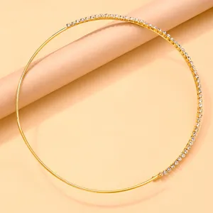 Primer plano de un collar choker asimétrico chapado en oro con diamantes de imitación.