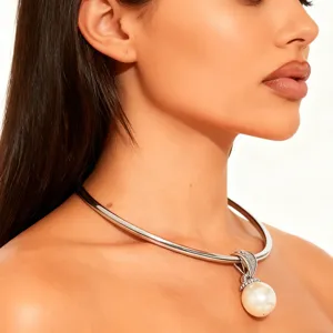 Primer plano detallado del collar gargantilla de metal minimalista con gran colgante de perla.