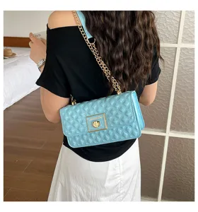 Detailed shot of the light blue quilted chain shoulder bag, featuring glossy texture and metallic lock.