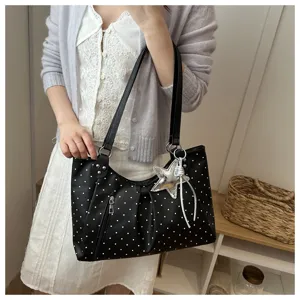 Detail view of casual black polka dot tote bag with star pendant, stylish daily wear.