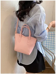 Chic pink leather handbag with double top handles and shoulder strap for women daily style.
