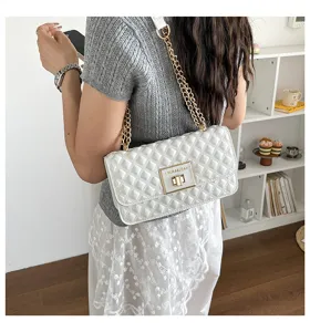 White quilted chain shoulder bag, stylish crossbody handbag with metal lock and strap.