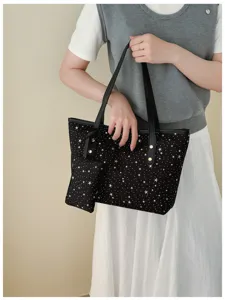 Detailansicht einer schwarzen Tasche mit weißem Sternenmuster, die Verarbeitung und Stil zeigt.