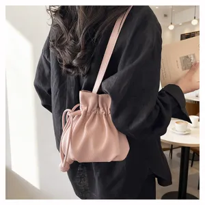 Sac seau élégant en cuir rose pour femme, sac à bandoulière minimaliste et tendance.