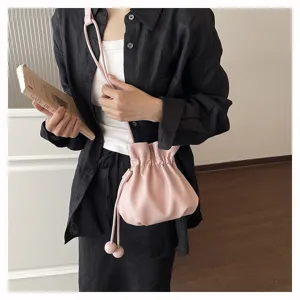 Sac seau élégant en cuir rose avec cordon de serrage, sac bandoulière minimaliste pour femme.