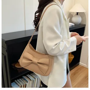 Chic beige crescent shoulder bag with a stylish bow, perfect for daily commuting and fashion wear.