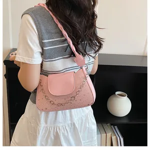 Stylish pink underarm shoulder bag with star details and chain strap for modern women.