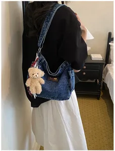 Casual denim τσάντα ώμου λεπτομέρεια, κομψή τσάντα μισοφέγγαρο με κρεμαστό αρκουδάκι.