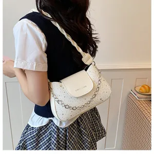 Stylish white underarm shoulder bag with star pattern, metallic chain detail, and elegant flap.