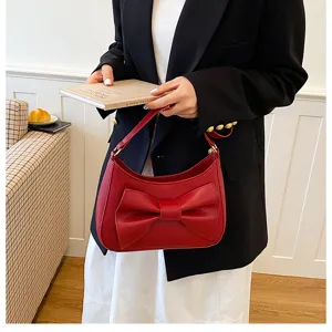 Chic red crescent shoulder bag with elegant bow detail, stylish hobo handbag for women.