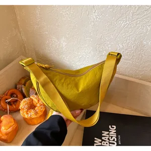 Borsa a dumpling in nylon stile giapponese, dettaglio di borsa a tracolla casual con cinturino largo.