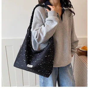 Detail view of the stylish black star print slouchy shoulder bag worn by model daily.