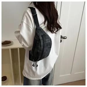 Detailed shot of casual grey sling chest bag worn by model, featuring textured fabric and strap.