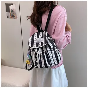 Detail view of casual black and white striped backpack with cute bows and drawstring closure.