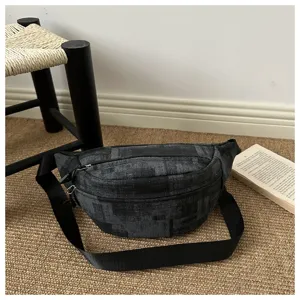 Detailed view of the dark grey patterned crossbody bag with black strap and zipper closure.