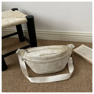 Detailed view of neutral beige checkered crossbody bag with wide strap and double zippers.