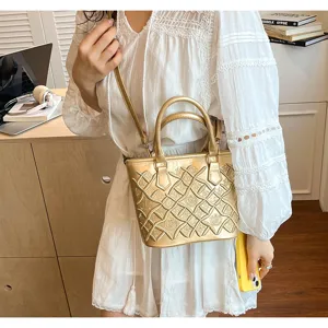 Metallic gold handbag featuring embossed lattice pattern, stylish top handle and crossbody strap.