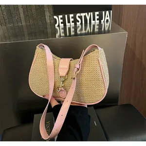 Stylish woven straw shoulder bag with pink leather trim and chic hobo design for women.