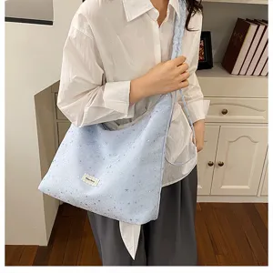 Detail shot of blue starry tote bag showing textured fabric and stylish slouchy shoulder design.