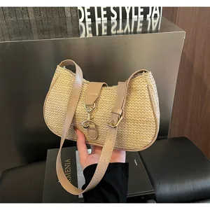 Detailed view of the stylish straw shoulder bag with leather strap and metal clasp.